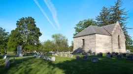 Grass, grave markers, and trees to the left; structure on the right