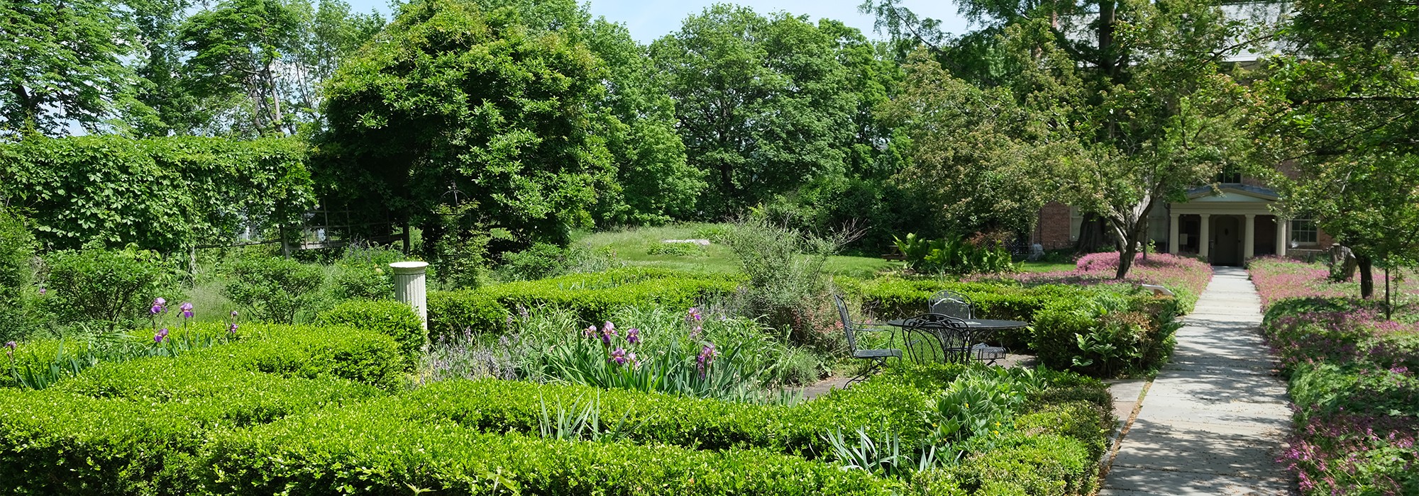 Path on the right, box hedges on the left; house in distance