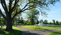 Tree and path on left, lawn and memorial on right