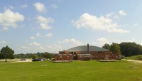 Broad lawn in foreground, brick building in background