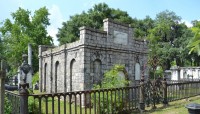 Mausoleum surrounded by a fence with trees in background