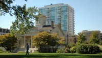 Lawn with tree and shrubs in foreground, buildings in background