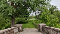 End of bridge with path and trees beyond
