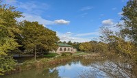 Building across the lake; lush trees surround