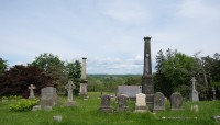 Grave markers in foreground, trees and blue sky in background