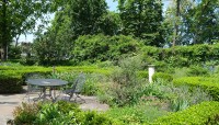 Patio with table and chairs in center of garden