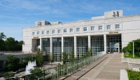 Walkway on the right with a lower level on the left; main focus is an academic building