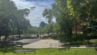 Circular courtyard surrounded by sloping lawn with trees