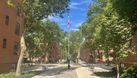 Brick buildings on the left and right, paved court in between with trees