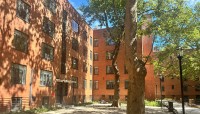 L-shaped brick building enclosing a courtyard with trees