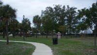 Curving sidewalk goes past the memorial; trees all around