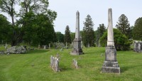 Grave markers in foreground, trees in background