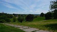 Diagonal path across the rolling lawn; trees in distance