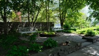 Raised flagstone patio with seating; trees surround
