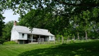 White, wood building on the left; fenced garden on the right