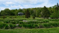 Spiral pathways covered in grass and other plants; visitors center in distance