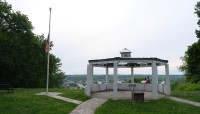 Gazebo overlooking the city; trees on either side
