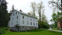 White, wood building in foreground; curving path and red building in background
