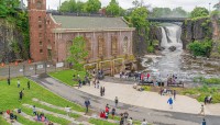 Hydroelectric building and park in foreground; waterfall and bridge in background