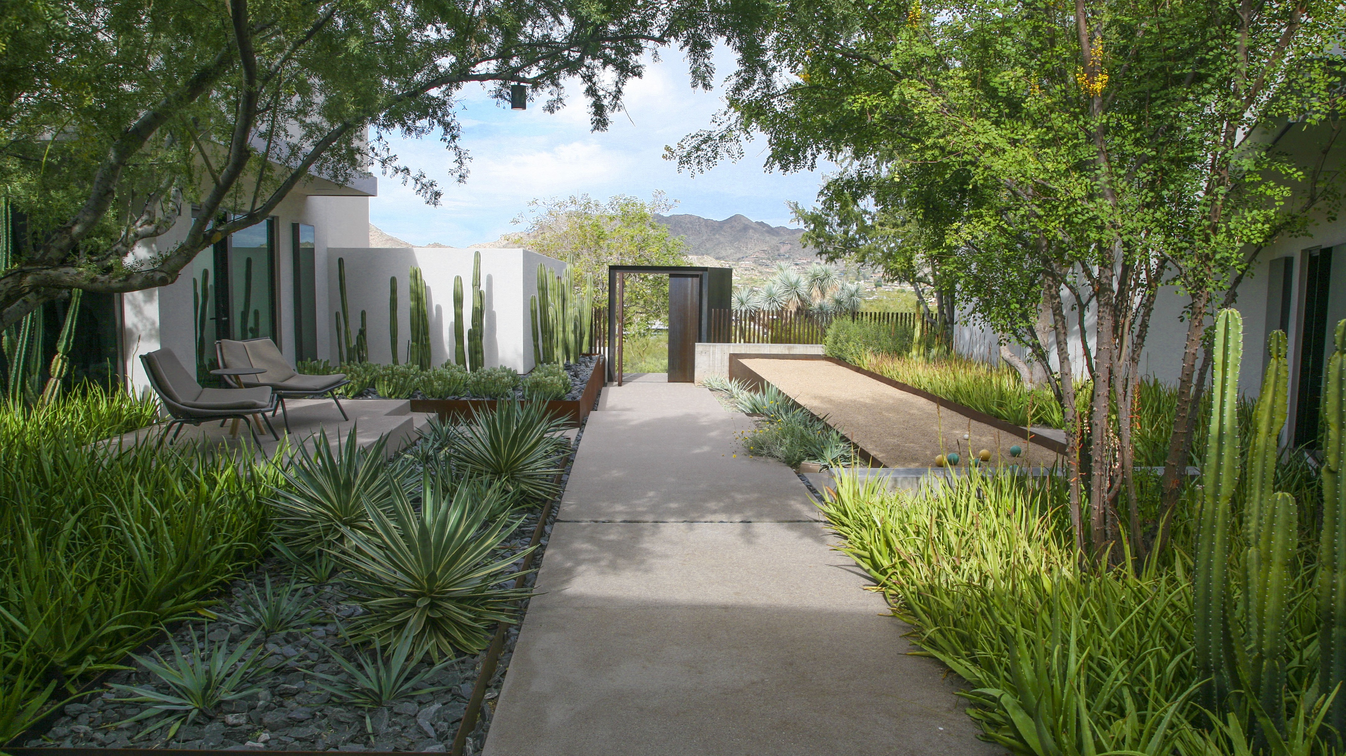 Pathway with plants on one side and bocce court on the other. 