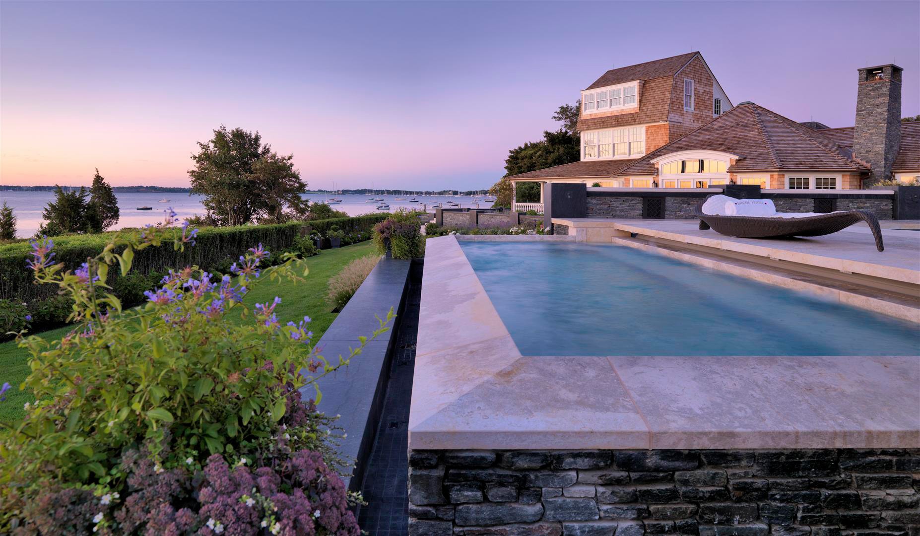 Pool and mansion overlooking Narraganset Bay at sunset