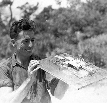 James Rose holding a model of his house made from scraps during World War II
