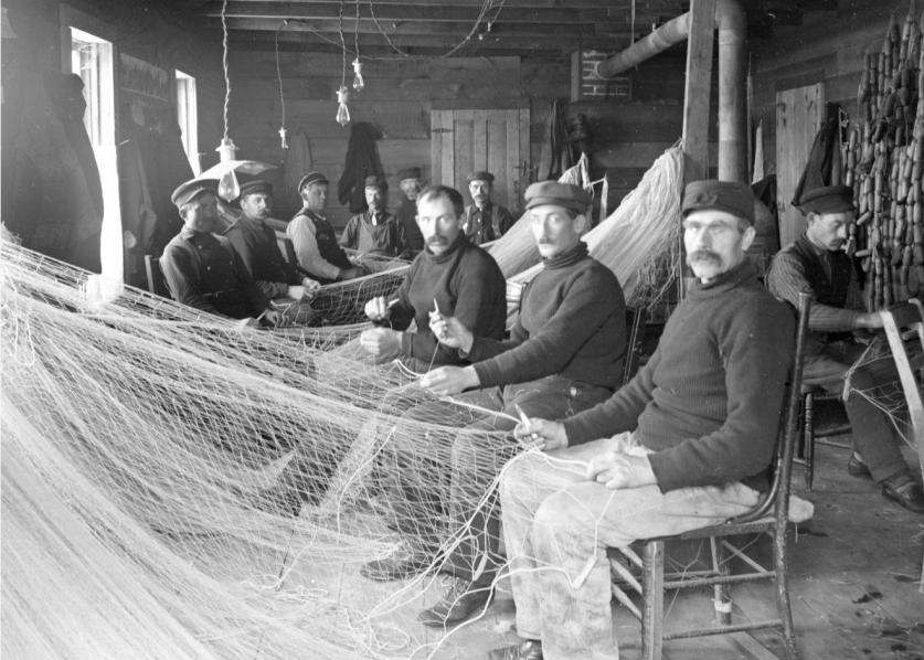 A net-mending crew of the A. Booth Fishery, based in the Apostle Islands, ca. 1900