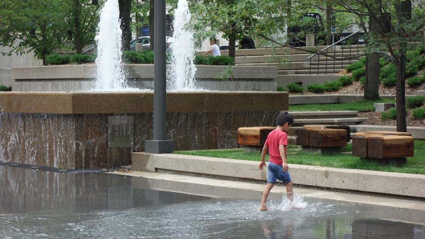 A child splashes in the rehabilitated basin of Peavey Plaza, Minneapolis, MN